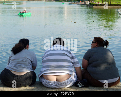 Drei über Gewicht Menschen saßen an einem Flussufer Stockfoto