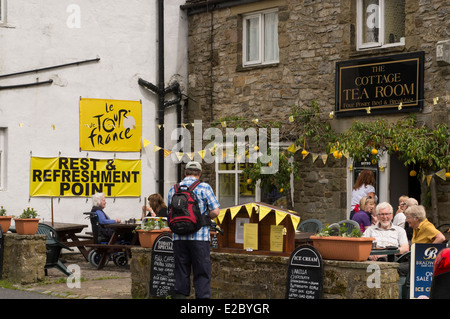 Menschen Erfrischungen genießen, Sitzen, Essen & Trinken im Freien in der Sonne - außerhalb der Hütte Teestube, Kettlewell, North Yorkshire, England, UK. Stockfoto