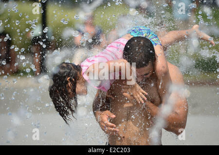 Washington, DC, USA. 18. Juni 2014. Ein Mann und seine Tochter spielen im Wasser des Brunnens in Washington, DC, USA, am 18. Juni 2014. Die Temperatur erreicht 35 Grad Celsius in Washington, DC am Mittwoch. Bildnachweis: Yin Bogu/Xinhua/Alamy Live-Nachrichten Stockfoto