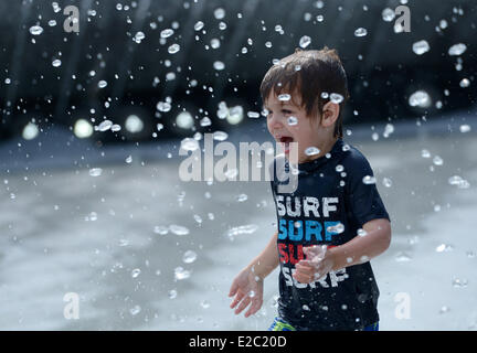 Washington, DC, USA. 18. Juni 2014. Ein Junge kühlt sich im Wasser des Brunnens in Washington, DC, den Vereinigten Staaten, am 18. Juni 2014. Die Temperatur erreicht 35 Grad Celsius in Washington, DC am Mittwoch. Bildnachweis: Yin Bogu/Xinhua/Alamy Live-Nachrichten Stockfoto