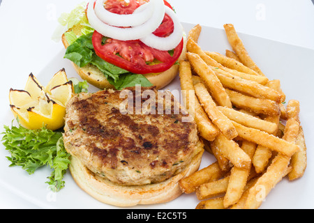 Pfanne gebraten Krabbe Kuchen Sandwich serviert mit einer Seitenlänge von Pommes Frites. Stockfoto