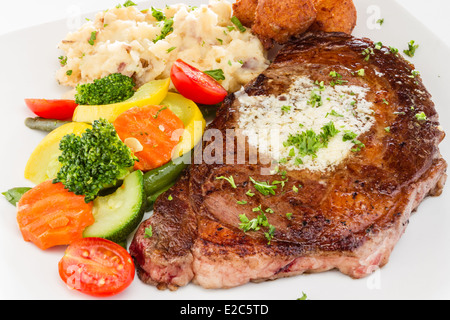 Ribeye Steak serviert mit Kartoffelpüree und Gemüse Medley Hush Welpen. Stockfoto