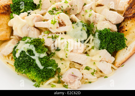 Chicken Alfredo mit Nudeln, Brokkoli und Knoblauchbrot. Stockfoto