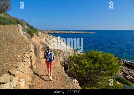 Italien, Sizilien, Ägadischen Inseln, Insel Levanzo, Cala Minola, Wanderer zu Fuß auf einem Weg am Berghang mit Meer im Hintergrund Stockfoto