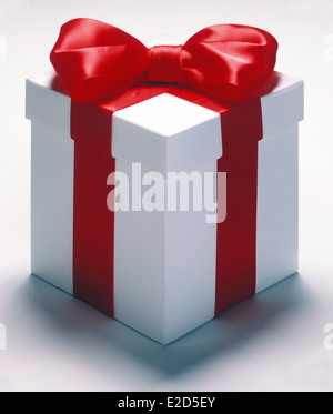 Ein Geschenk in Form von einem weißen Kasten mit rotem Band und eine rote Schleife auf der Oberseite der Box auf einem weißen Hintergrund. Stockfoto