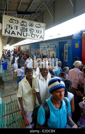 Sri Lanka, Central Province, Nuwaraelyia Bezirk, Nanu Oya, Railway station, geht und kommt von Reisenden auf einer Plattform vor blauen Autos Stockfoto