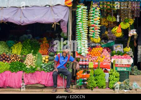 Central Province, Matale-Distrikt, Sri Lanka, Dambulla, junger Mann saß vor dem Schaufenster mit einem Gemüsehändler gefärbt Stockfoto