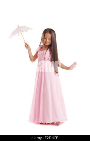 Langhaarige kleine Brünette posiert in rosa Kleid Stockfoto