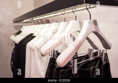 Kleidung zu hängen, auf einem Regal in einem Designer-Kleidung Geschäft in Melbourne, Australien Stockfoto