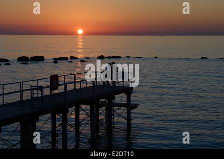 Eine Silhouette paar beobachten Sie den Sonnenuntergang am Meer, Zypern dargelegt Stockfoto