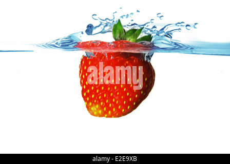 Frische rote Erdbeere in das blaue Wasser mit splash Stockfoto