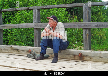 Lebensstil der ländlichen Sommer 2013. Die Einwohner des Dorfes hat einen Rest - sitzt auf dem Bürgersteig der Holzbrücke. Stockfoto