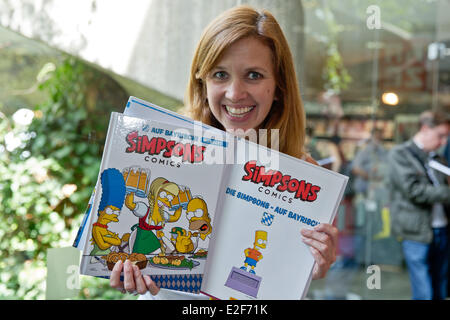 Erlangen, Deutschland. 19. Juni 2014. Die Synchronsprecherin der Cartoon-Serie "The Simpsons", Sabine Bohlmann, zeigt bayerische Versionen von "The Simposns" Comic-Bücher während der 16. Festival der Internationalen Comic-Salon in Erlangen, Deutschland, 19. Juni 2014. Bohlman übersetzt Comics in bayerischen Dialekt. Das größte Comic-Festival für die deutschsprachigen Märkte läuft bis 22 Juni. Foto: DANIEL KARMANN/Dpa/Alamy Live News Stockfoto