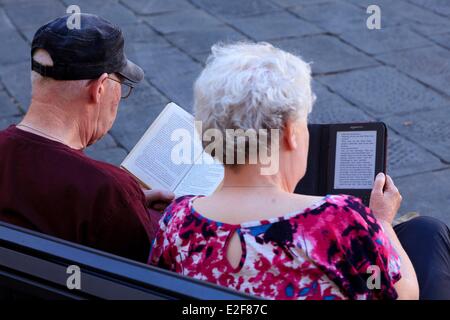 Italien, Toskana, Lucca, paar Rentner lesen ein Buch und ein e-Book-reader Stockfoto