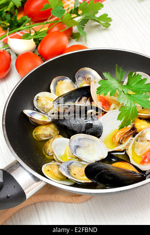 Braten Sie, Fisch und Meeresfrüchte in einer Pfanne mit Olivenöl und Petersilie Stockfoto