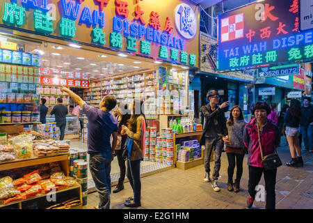 China Hong Kong Kowloon Bezirk Bezirk von Mongkok Ladies Market Nacht Wanderer vor einer chinesischen traditionellen Apotheke in Stockfoto