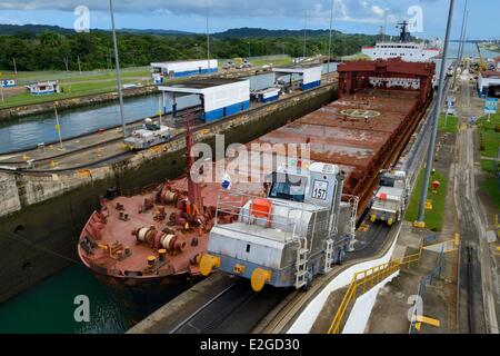 Panama Doppelpunkt Provinz Panama-Kanal Gatun sperrt mechanische Maultiere oder elektrische Lokomotiven, die Führung einer Panamax-Ladung zwischen Schloss Wände Stockfoto