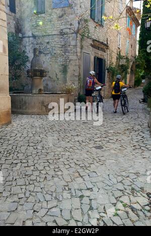 Frankreich Vaucluse Seguret gekennzeichnet, Les Plus Beaux Dörfer de France (die schönsten Dörfer Frankreichs) Calade typisch provenzalischen Straße mit Kopfsteinpflaster und Brunnen Fontaine des Mascarons des 17. Jahrhunderts im Hintergrund Stockfoto