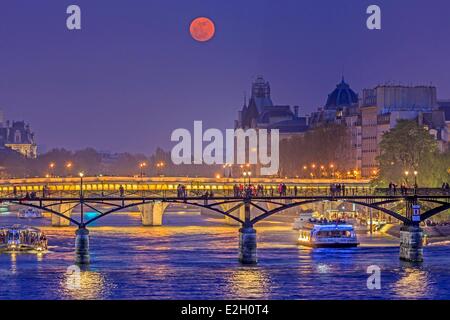 Frankreich Paris Ufer der Seine als Weltkulturerbe der UNESCO Pont des Arts (Kunst-Brücke) und Fluss Brücke Pont Neuf und Conciergerie im Hintergrund unter Vollmond Boote aufgeführt Stockfoto