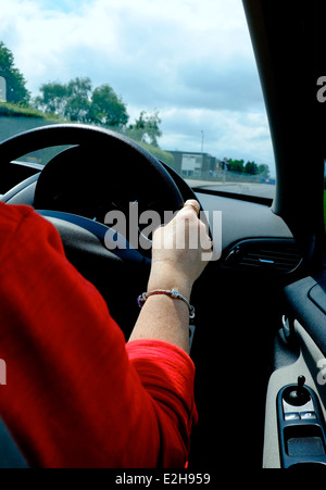 Eine Frau zeigt ihre Rechte Hand auf das Lenkrad England UK Autofahren Stockfoto