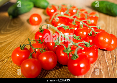 Cherry-Tomaten auf einem Ast. In der Nähe von Gurken und Gemüse. Stockfoto