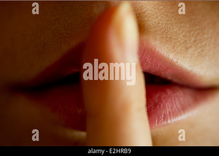 Frau mit Finger auf die Lippen Stockfoto