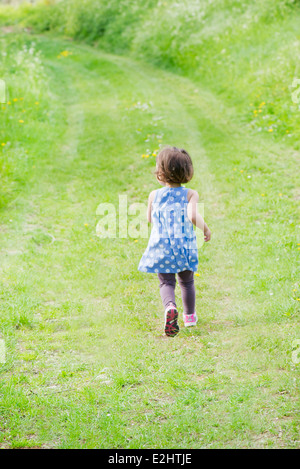 Kleines Mädchen läuft am Weg durch die Landschaft, Rückansicht Stockfoto