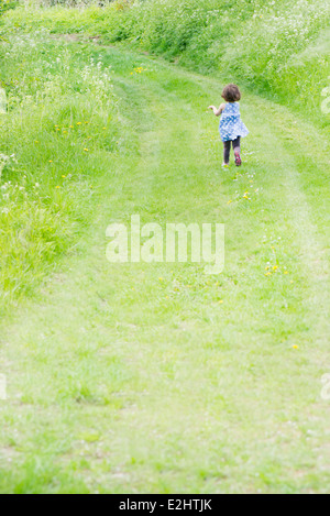 Kleines Mädchen läuft auf Feldweg, Rückansicht Stockfoto