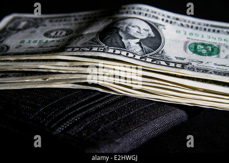 Haufen von amerikanischen einem Dollar-Scheine auf eine schwarze Geldbörse Stockfoto