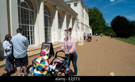 Mutter schiebt Kinderwagen vor Kenwood House in Sommersonne Sonnentag Juni in Nord-London NW3, Großbritannien KATHY DEWITT Stockfoto