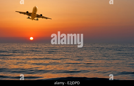 Flugzeug kommt ins Land gegen einen wunderschönen Sonnenuntergang Himmel Stockfoto