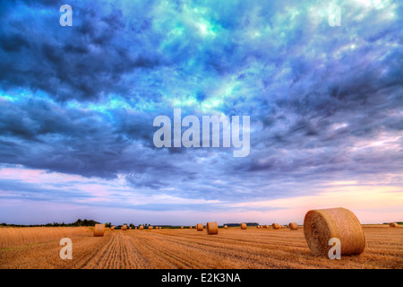 Sonnenuntergang über Feld-Hof mit Heuballen Stockfoto