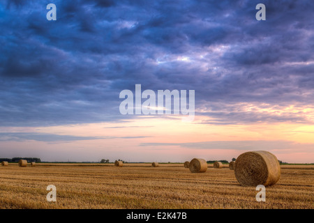 Sonnenuntergang über Feld-Hof mit Heuballen Stockfoto