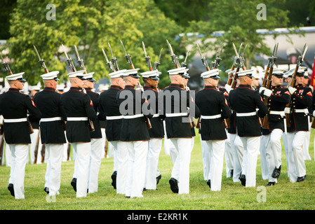 Marine Corps Silent Drill Platoon Arlington Virginia | ARLINGTON, Virginia — Marines des Silent Drill Platoons marschieren mit aufgepflanzten Bajonetten in Formation während der Sunset Parade am Marine Corps War Memorial, Gewehre über dem Kopf gekreuzt in einer der charakteristischen Manöver der Einheit. Das aus 24 Mitgliedern bestehende Platoon, das 1948 in der Marine Barracks Washington gegründet wurde, führt die Abfolge ohne einen einzigen verbalen Befehl aus. Stockfoto