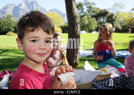 Picknick auf dem Rasen an Boschendal Weingut mit seinen jungen Freunden junge Stockfoto