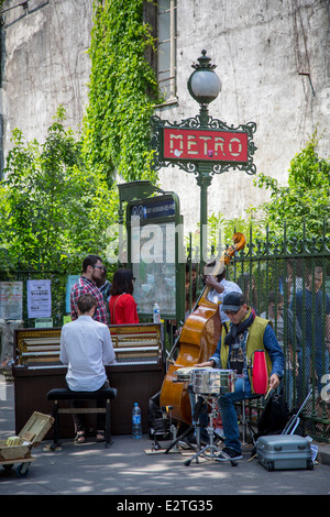 Straßenmusikanten - 3 köpfige Band auf Bürgersteig an der Metro-Haltestelle in Saint Germain des Prés, Paris Frankreich Stockfoto