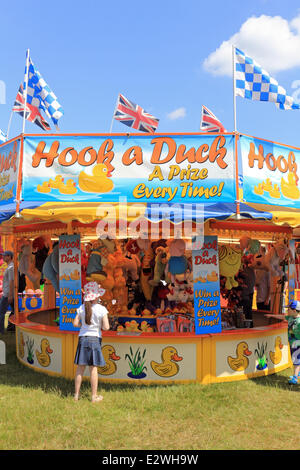 Wimbledon Common, London SW19 UK. 21. Juni 2014. Mädchen dem Haken eines Spiels Duck The Wimbledon Village Fair, eine jährliche Veranstaltung, die mehr als 20.000 Besucher anzieht. Alle Gelder werden verwendet, um lokale gemeinnützige Projekte zu unterstützen. Es ist ein toller Tag für die Familie mit Highlights wie ein Reitturnier, Ponyreiten, Stände verkaufen eine Vielzahl von Gütern, live-Musik und ein Jahrmarkt. Bildnachweis: Julia Gavin/Alamy Live-Nachrichten Stockfoto