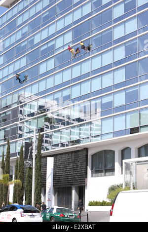 Zwei Tänzer Federbein ihre Sachen beim Abseilen an der Seite eines Bürogebäudes in Los Angeles. Ein Filmteam erfasst die actio Stockfoto