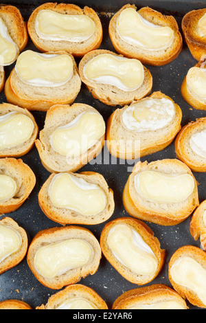 Draufsicht der vielen geröstetes Stück Brot mit geschmolzenem Ziegenkäse auf heiße Tablett Stockfoto