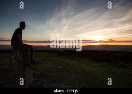 Ein Rollator sitzen auf der Orientierungstafel auf der Oberseite der Long Mynd beobachten den Sonnenuntergang über der Stiperstones, Shropshire, UK Stockfoto