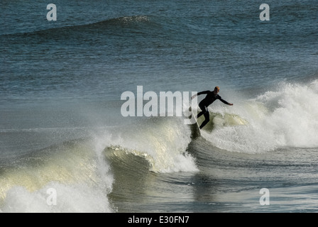 Florida-Surfer schnitzt eine Welle in Jacksonville Beach im Nordosten Floridas. USA. Stockfoto