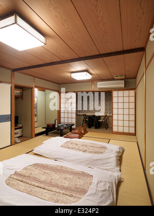 Traditionelle japanische Zimmer in einem Ryokan mit Futon Shikibuton auf dem Boden. Kyoto, Japan. Stockfoto