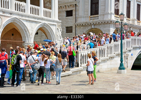 Massen Sommer Sightseeing Touristen zu Fuß über Fußgängerbrücke über den schmalen Kanal Brücke zwischen den Ecken von Doges Palace & New Prison Venice Venetien Italien Stockfoto