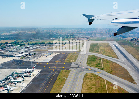 Flugzeug aus der Vogelperspektive auf die Start- und Landebahn und die Rollwege zu den Terminalgebäuden vom Jet über dem italienischen Flughafen Rom Fiumicino in Italien Stockfoto