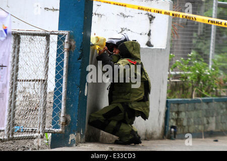 Quezon City. 22. Juni 2014. Ein Mitarbeiter aus der Bomb Squad von der Philippine National Police (PNP) Bombe Anzug hält ein verdächtiges Paket während einer Bombendrohung in der PNP Hauptsitz in Quezon City, Philippinen am 22. Juni 2014. Die Bombendrohung erwies sich als negativ sein, nachdem die Polizei im Inneren der Box Papiere gefunden. Bildnachweis: Rouelle Umali/Xinhua/Alamy Live-Nachrichten Stockfoto