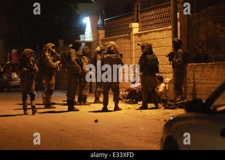 Bethlehem. 22. Juni 2014. Israelische Soldaten verhaften Palästinenser während einer militärischen Operation zu suchen drei entführten israelischen Jugendlichen im Westjordanland Stadt von Beit Sahour nahe Bethlehem, 22. Juni 2014. Die israelische Armee schoss tot früh am Sonntag zwei Palästinenser im Westjordanland, Medizin und Sicherheit Quellen sagten. Palästinensische Sicherheitsquellen sagte Xinhua, dass große israelische Truppen ein Flüchtlingslager stürmten und Dutzende von Häusern, auf der Suche nach drei vermissten Israelis im Westjordanland im Juni 12 verschwundenen überfallen. Bildnachweis: Luay Sababa/Xinhua/Alamy Live-Nachrichten Stockfoto