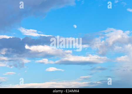 Mond und graue Wolken im blauen Abendhimmel im Sommer Stockfoto