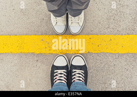 Sneakers von oben. Männliche und weibliche Füße in Turnschuhen von oben stehenden Trennlinie. Stockfoto