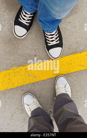 Sneakers von oben. Männliche und weibliche Füße in Turnschuhen von oben stehenden Trennlinie. Stockfoto