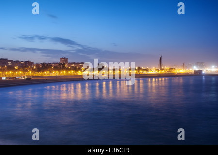 Mittelmeer entlang der Icaria-Strand in der Abenddämmerung in der Stadt Barcelona in Katalonien, Spanien. Stockfoto